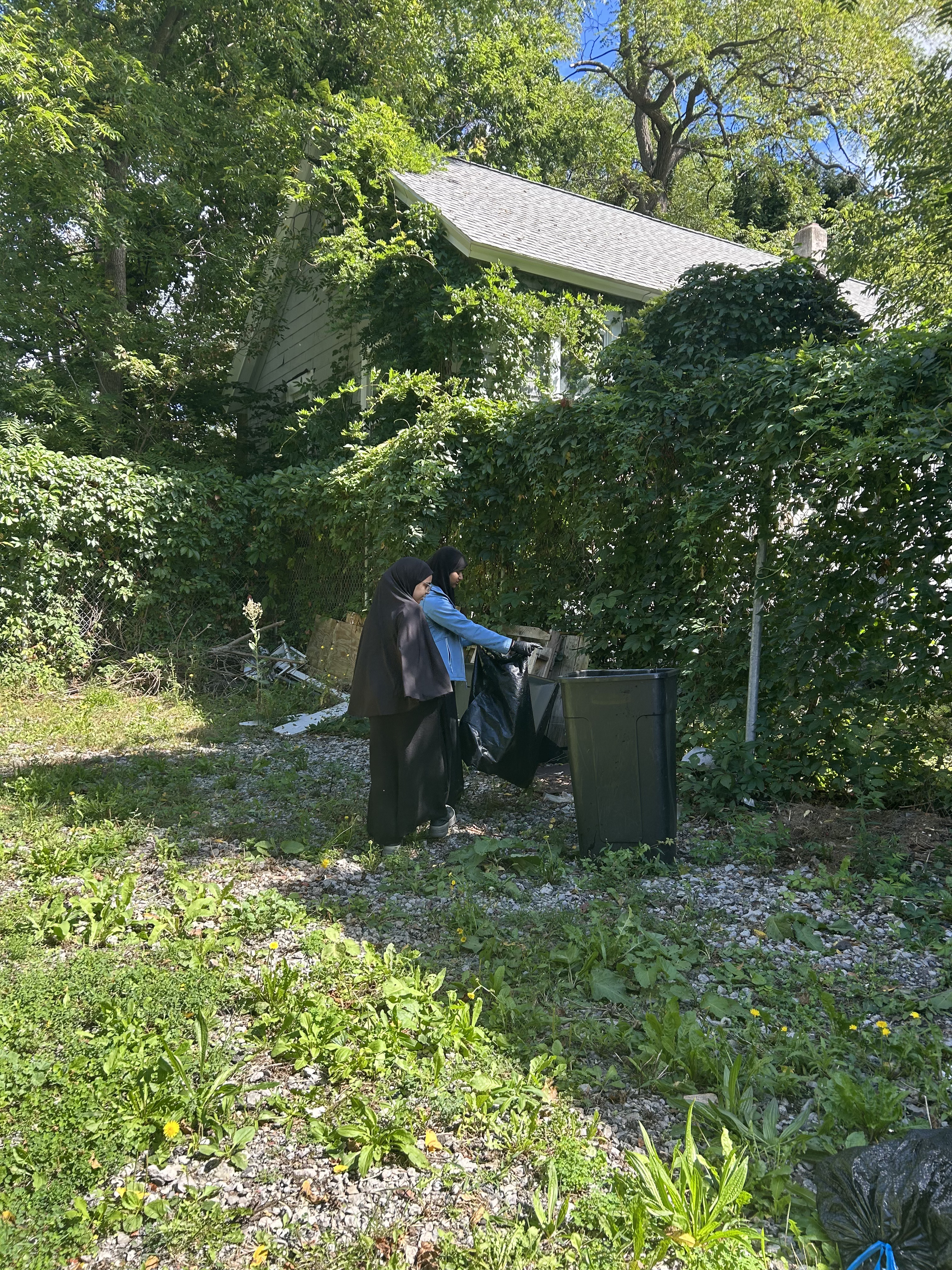 Students placing collected trash into a bin